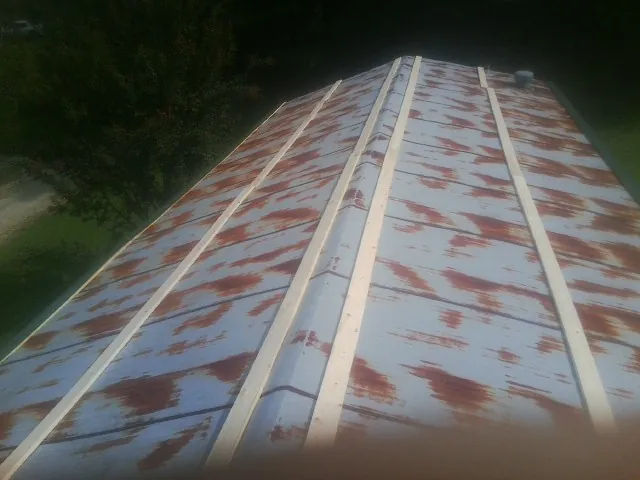 Rusted metal roof panels with new wood purlins before replacement — Storm Damage Roof Repair in Gate by Roofing Brothers